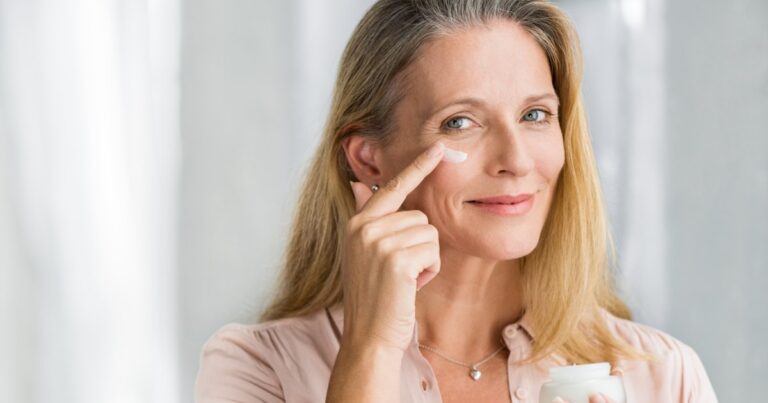 Mature Woman Applying Moisturizer Stock Photo