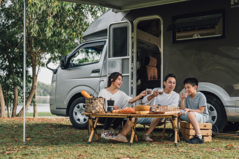 a group of people camping in front of an rv