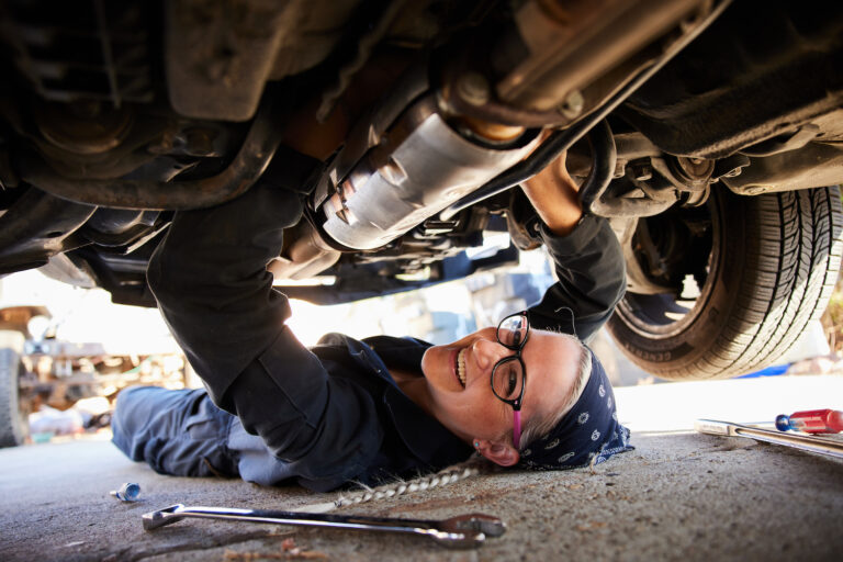 a woman works on her car