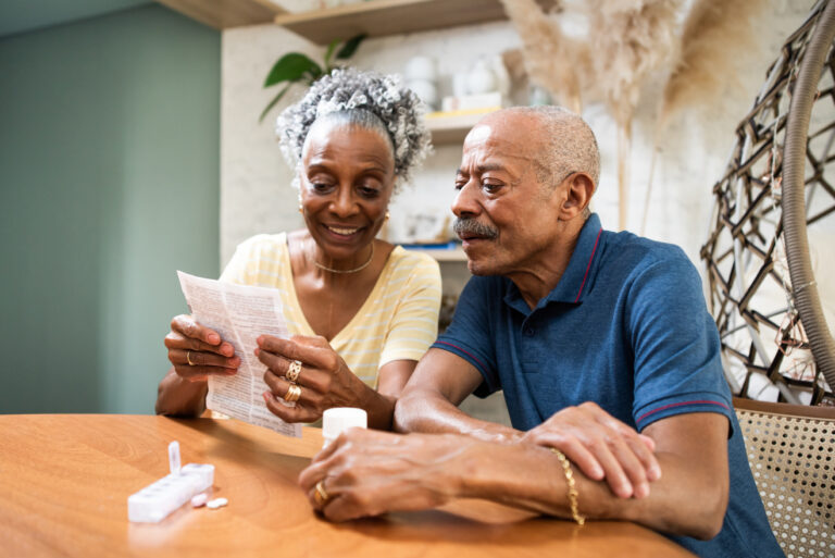 couple sitting at table looking at document