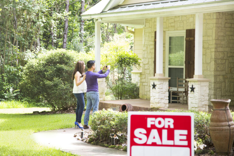 couple standing outside house for sale