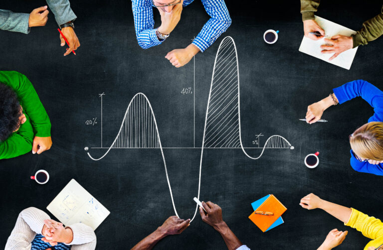 people sitting around a blackboard with a parabolic curve