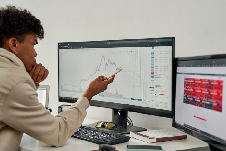 analyst studying stock chart on a desktop screen