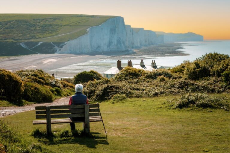 person sitting on a bench overlooking water