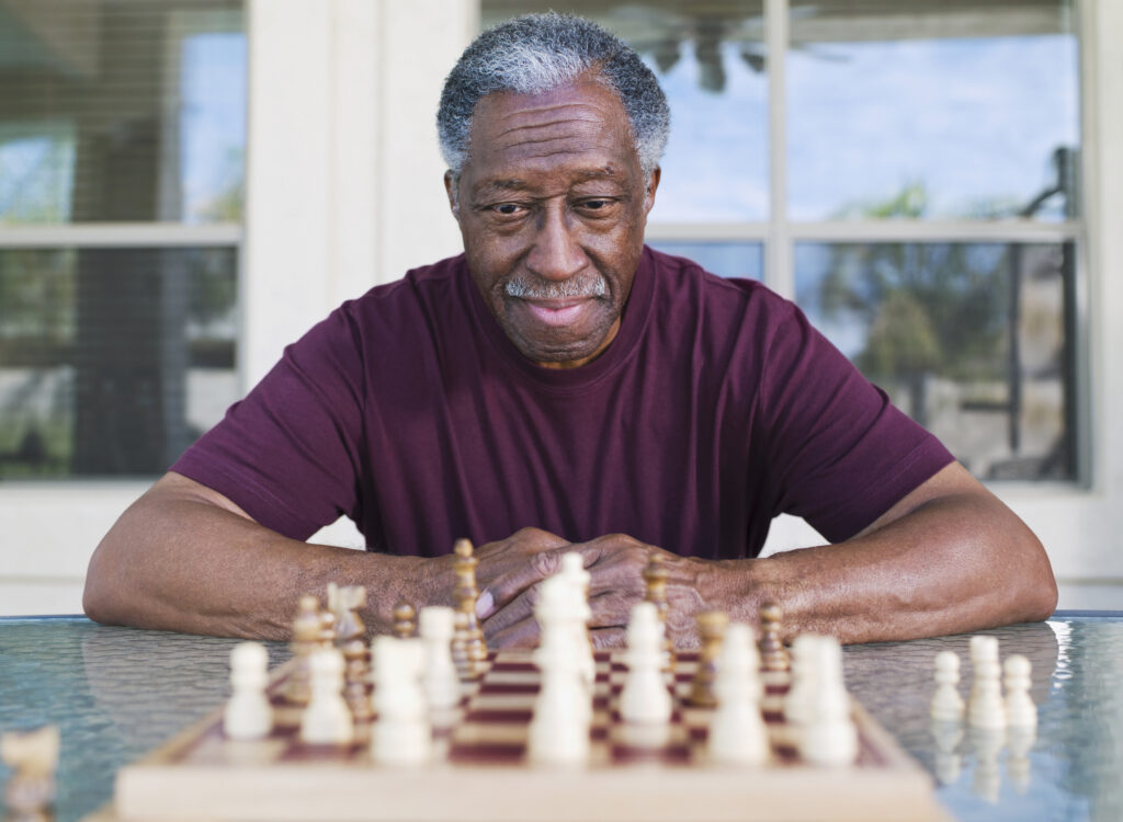 older man playing chess strategy moves winning