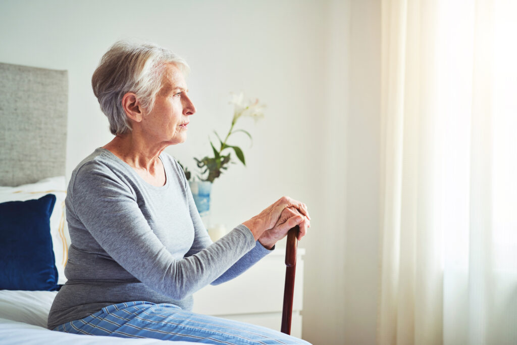 elderly person sitting on a bed