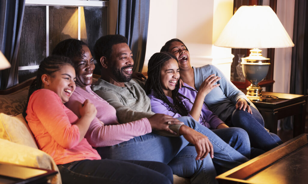 family laughing in tv couch