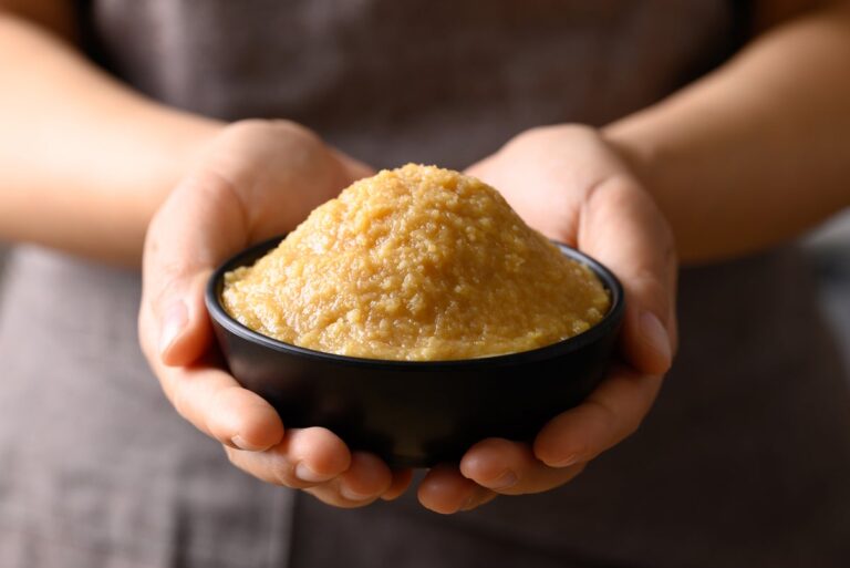 hands holding miso paste in bowl