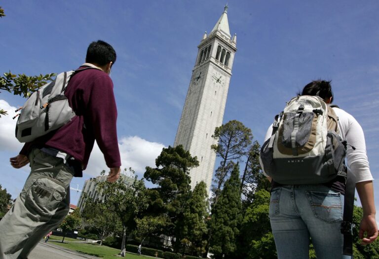 students walk by sather tower on uc berkeley campus